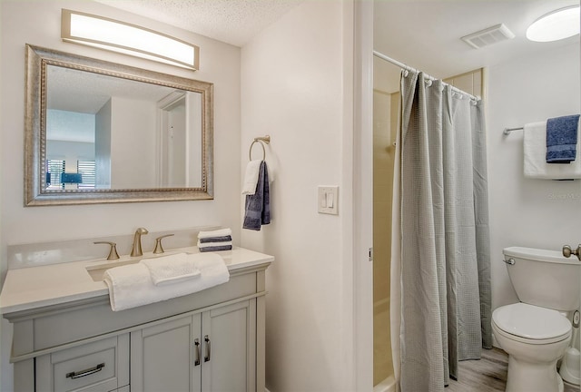 bathroom featuring a shower with curtain, vanity, a textured ceiling, wood-type flooring, and toilet