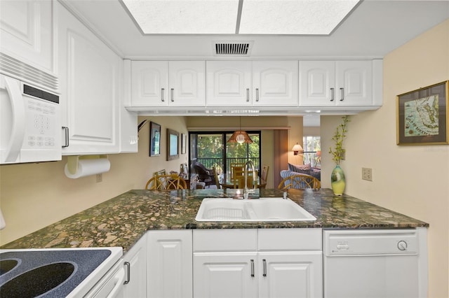 kitchen featuring kitchen peninsula, dark stone countertops, sink, white cabinets, and white appliances