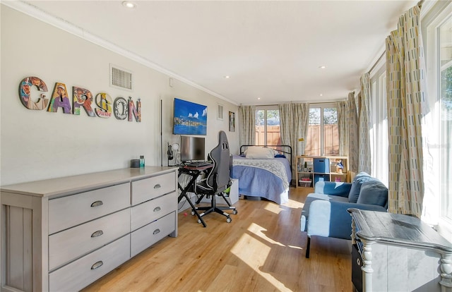 bedroom featuring ornamental molding and light hardwood / wood-style floors