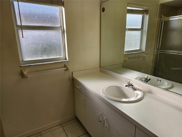 bathroom featuring tile patterned floors, vanity, and a shower with shower door