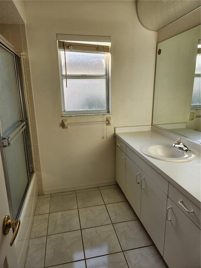 bathroom with vanity and bath / shower combo with glass door