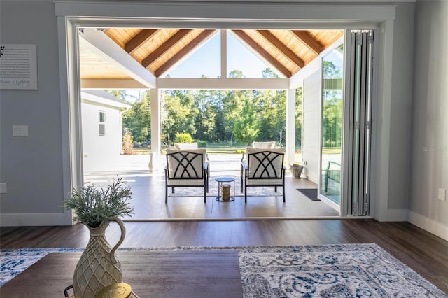 entryway with dark hardwood / wood-style floors and vaulted ceiling with beams