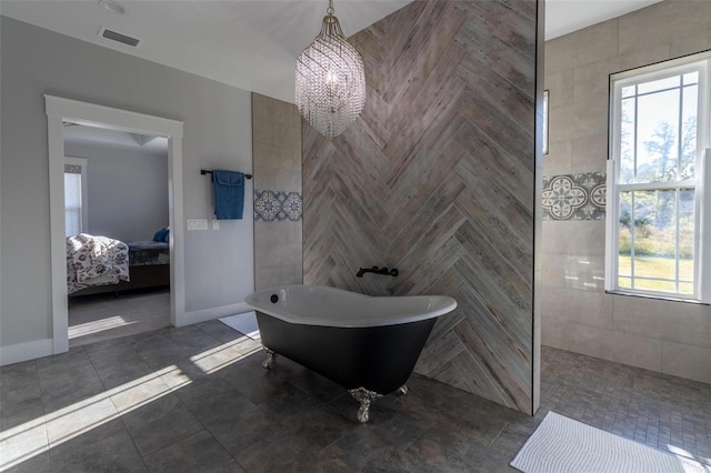 bathroom featuring a chandelier and a bathtub