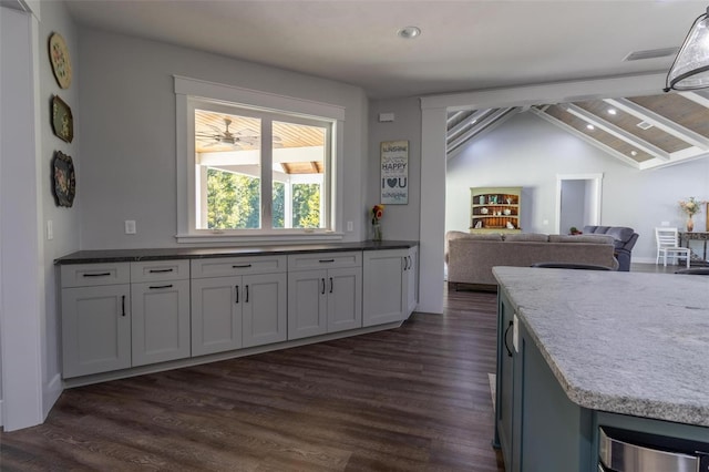 kitchen featuring white cabinets, dark hardwood / wood-style flooring, and vaulted ceiling with beams