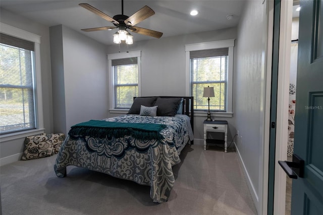 bedroom with multiple windows, ceiling fan, and carpet flooring