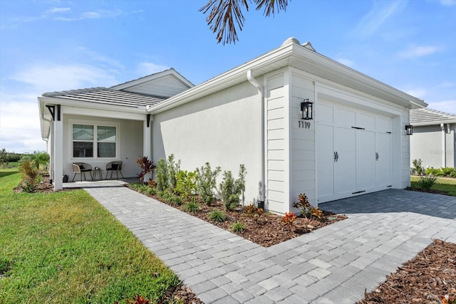 view of front facade featuring a garage, a front lawn, and a porch