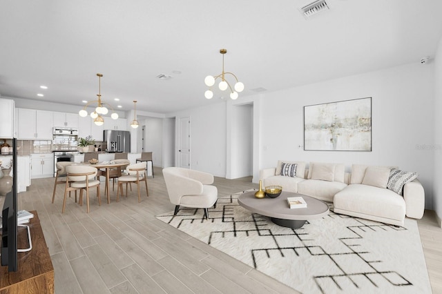 living room featuring a notable chandelier and light hardwood / wood-style floors