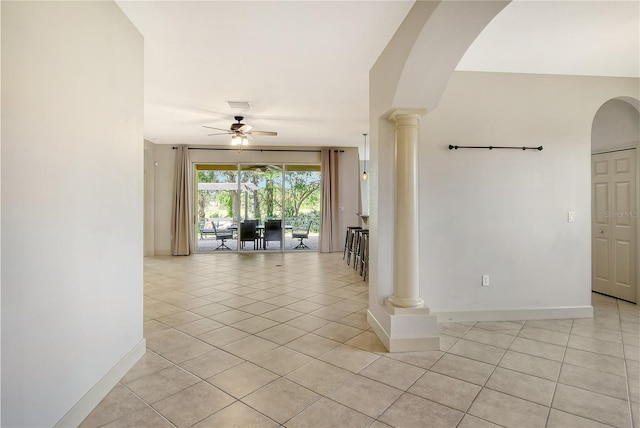 interior space with decorative columns, light tile patterned flooring, and ceiling fan