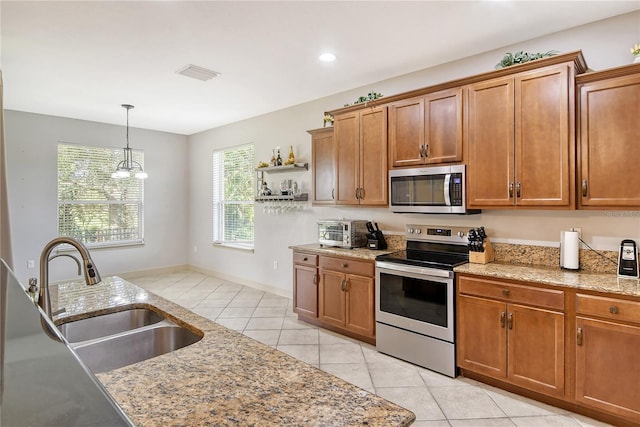 kitchen featuring appliances with stainless steel finishes, light tile patterned flooring, pendant lighting, a notable chandelier, and sink