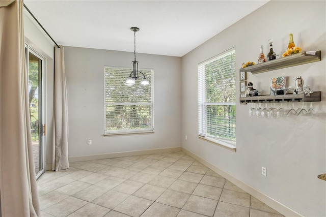 unfurnished dining area featuring a notable chandelier and light tile patterned flooring