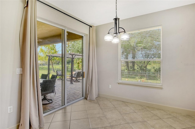 unfurnished dining area featuring a wealth of natural light, a chandelier, and light tile patterned floors