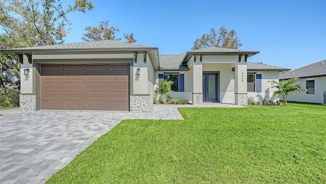 view of front of home with a front yard and a garage