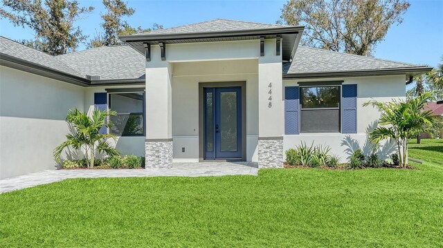 view of exterior entry with a yard