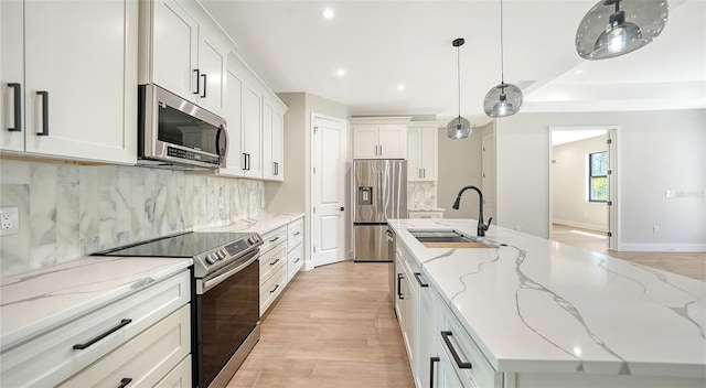 kitchen with appliances with stainless steel finishes, white cabinetry, and sink