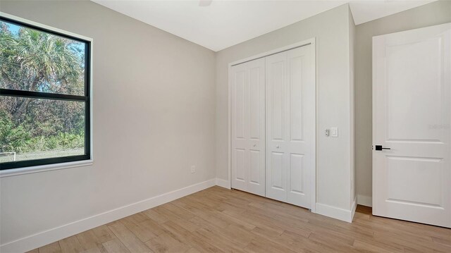 unfurnished bedroom with a closet and light hardwood / wood-style floors