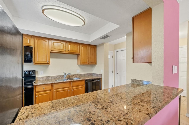 kitchen with black appliances, light stone countertops, and sink