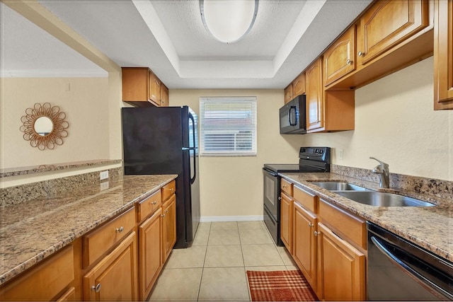 kitchen with black appliances, sink, ornamental molding, light tile patterned floors, and a tray ceiling