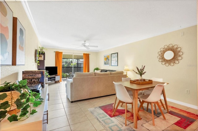 tiled dining area with ceiling fan and ornamental molding