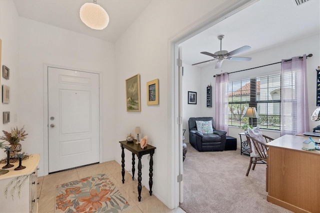 entryway featuring ceiling fan and light carpet