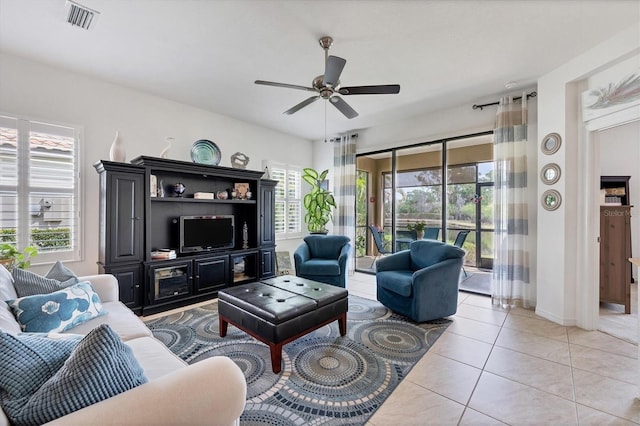 tiled living room featuring ceiling fan and a healthy amount of sunlight