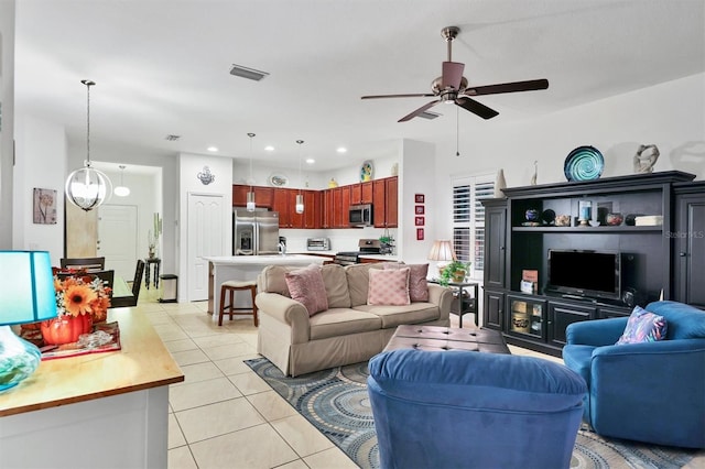 living room featuring light tile patterned flooring and ceiling fan with notable chandelier