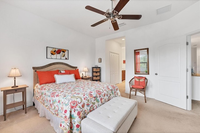 bedroom featuring light carpet, ensuite bath, ceiling fan, and a closet