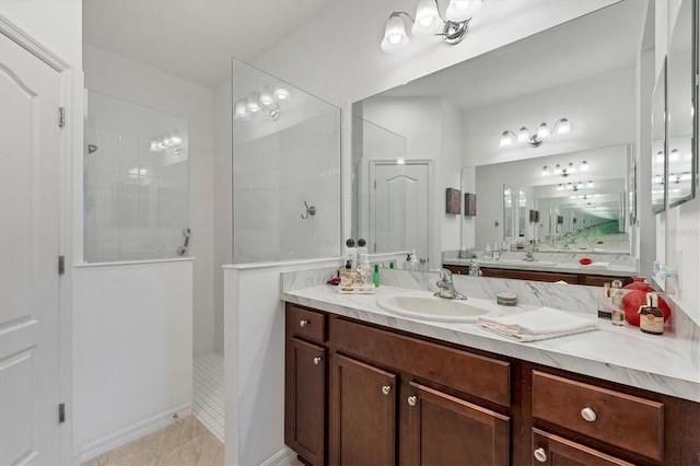 bathroom featuring vanity, tile patterned flooring, and a tile shower