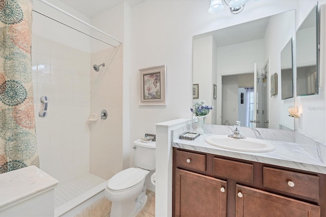 bathroom with a tile shower, tile patterned floors, vanity, and toilet