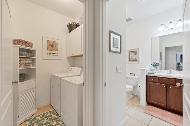 clothes washing area featuring washing machine and dryer, cabinets, light tile patterned floors, and sink