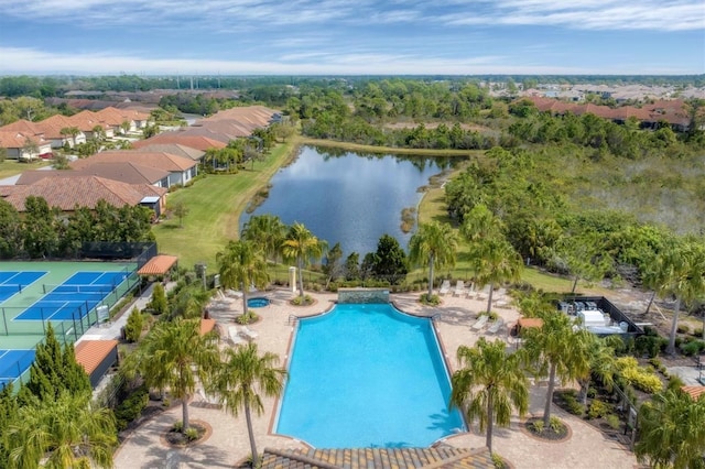 community pool featuring a water view, a residential view, and a patio