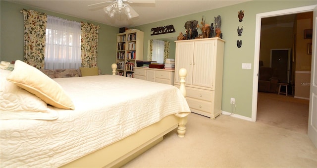 bedroom with baseboards, ceiling fan, and light colored carpet