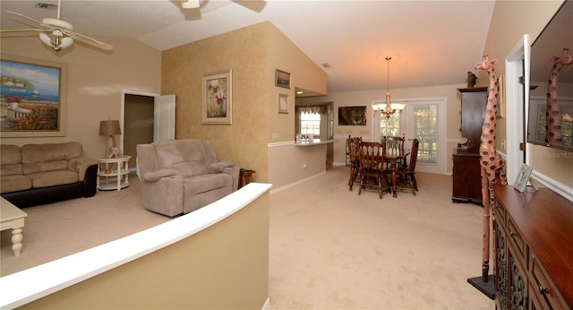 carpeted living room with baseboards, visible vents, vaulted ceiling, and ceiling fan with notable chandelier