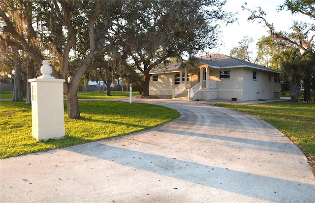 view of front facade featuring a front yard and curved driveway