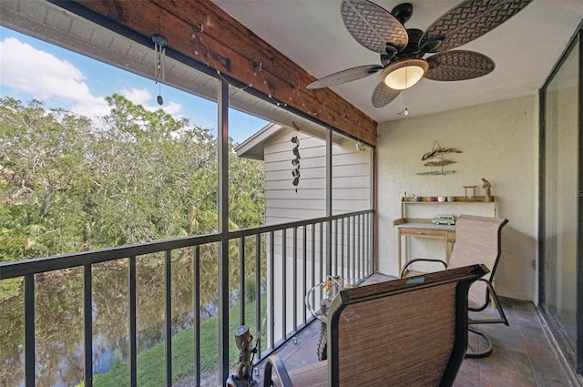 balcony with a water view and ceiling fan