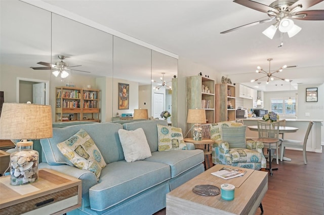 living room with wood-type flooring and ceiling fan with notable chandelier