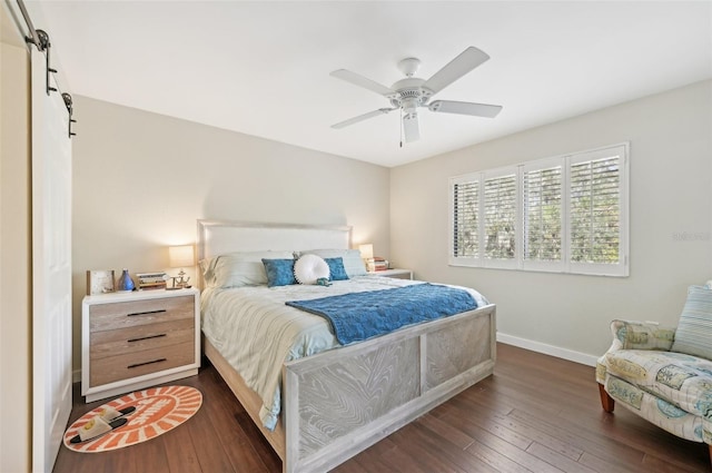 bedroom featuring dark wood-type flooring, a barn door, and ceiling fan