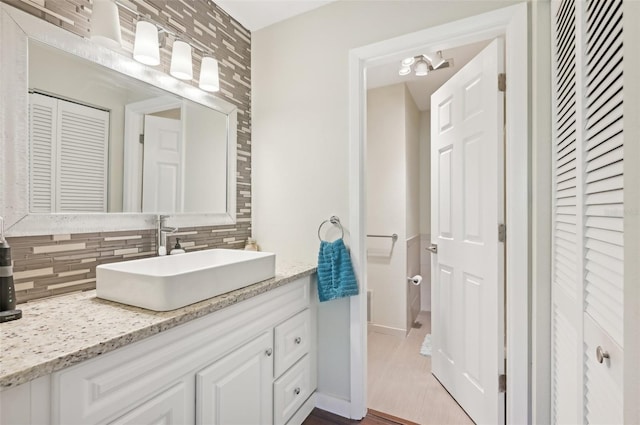 bathroom with vanity, backsplash, and wood-type flooring