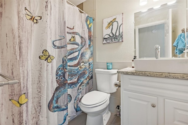 bathroom featuring curtained shower, vanity, and toilet