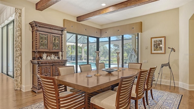 dining space with beamed ceiling and hardwood / wood-style floors