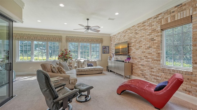 carpeted living room featuring ceiling fan, ornamental molding, and a wealth of natural light