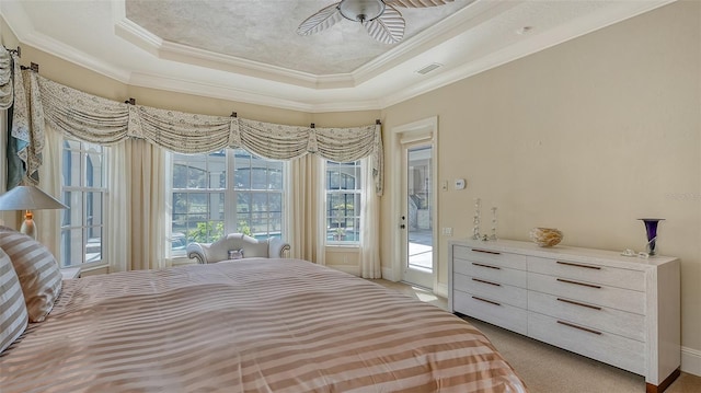 carpeted bedroom with access to outside, ceiling fan, a tray ceiling, and ornamental molding