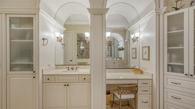 bathroom with walk in shower, decorative columns, vanity, and ornamental molding