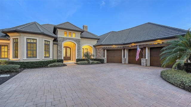 french provincial home featuring a garage