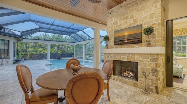 sunroom featuring lofted ceiling, a fireplace, and a wealth of natural light