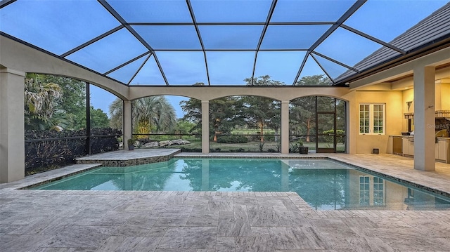 view of pool with glass enclosure and a patio