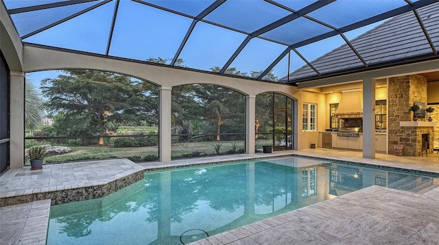 view of swimming pool with area for grilling, a patio area, and exterior kitchen