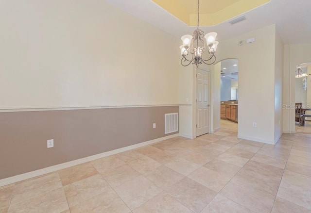 empty room featuring an inviting chandelier and light tile patterned flooring