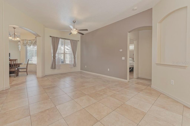 empty room with light tile patterned flooring and ceiling fan with notable chandelier