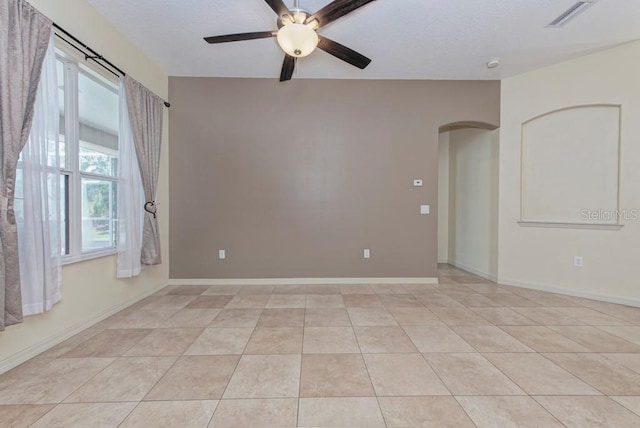 tiled spare room featuring ceiling fan