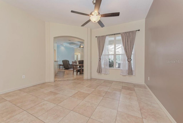 spare room with ceiling fan and light tile patterned floors